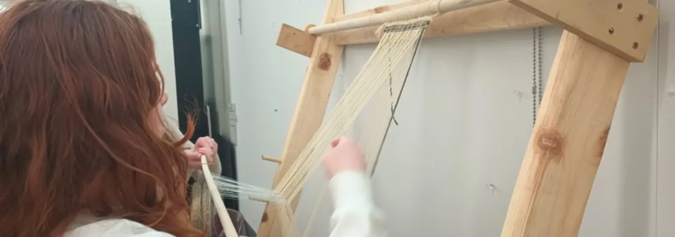 Student weaving on a handmade loom