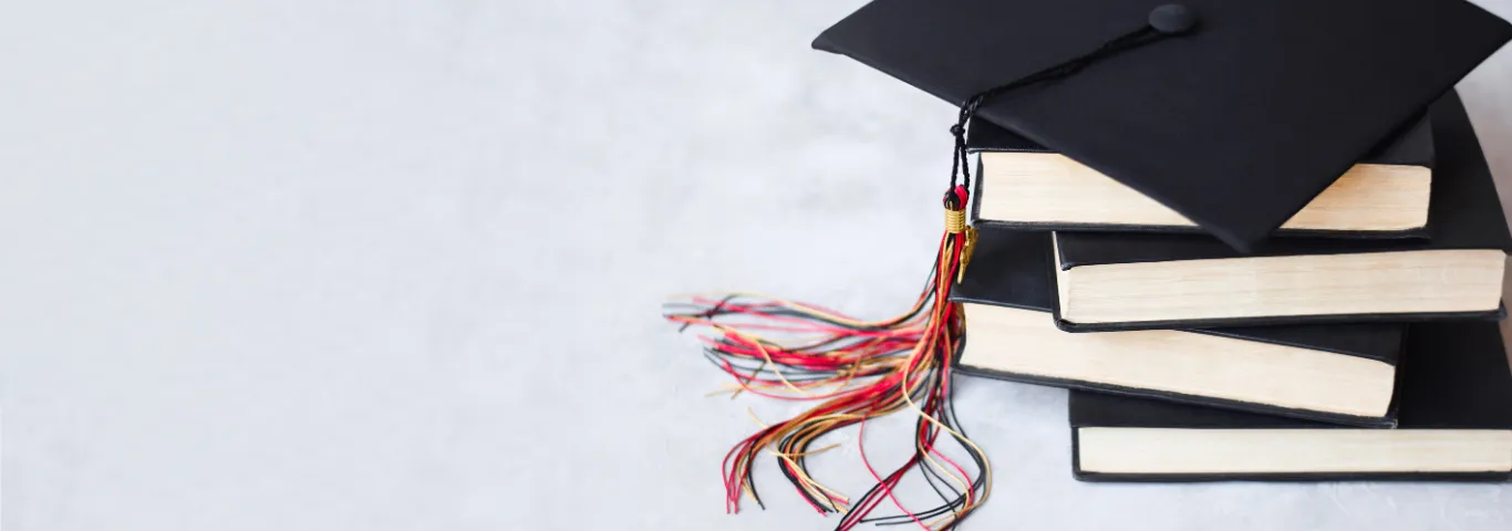 graduation cap atop books