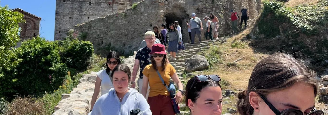 Students descending a staircase at a ruins in Greece