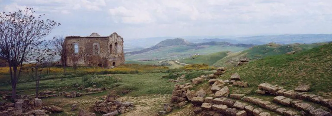 landscape with amphitheater ruins and stone house