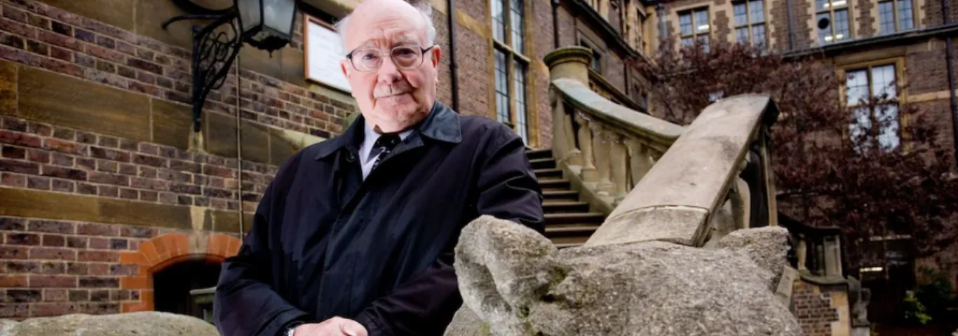 Colin Renfrew outiside leaning against a stone banister