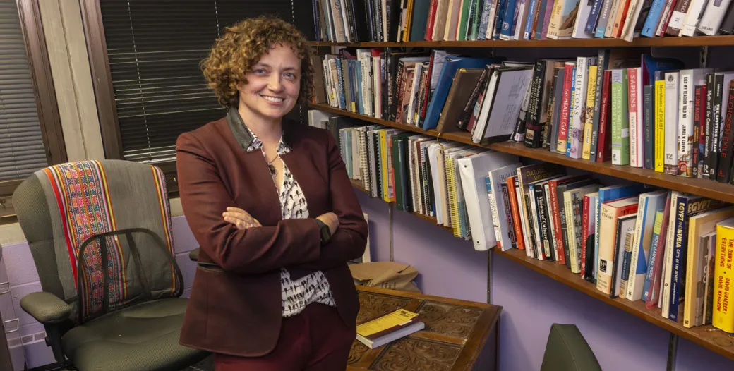 Austin in her office in front of a wall of books