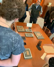 students gather around a table of papyri under glass in Olin Special Collections