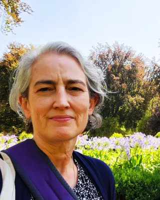 headshot of Cathy Keane in front of a bed of flowers
