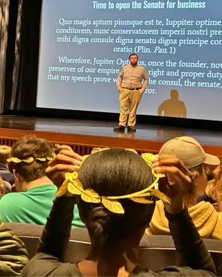 Student places laurel wreath on her head