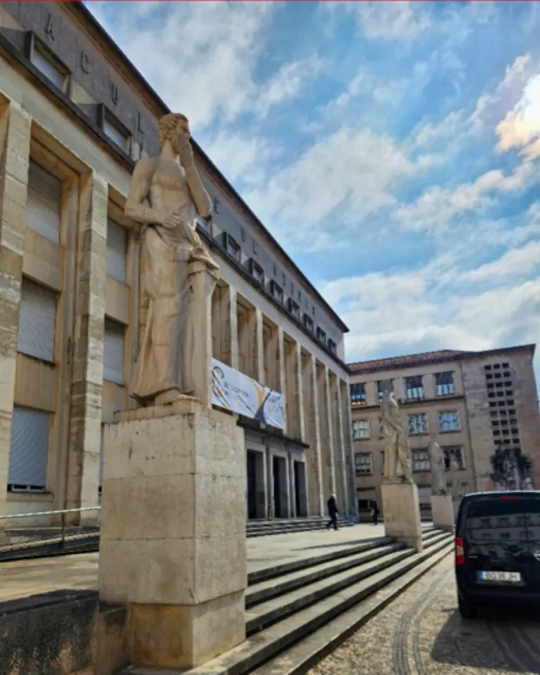 Classics inspired statuary in front of stone building