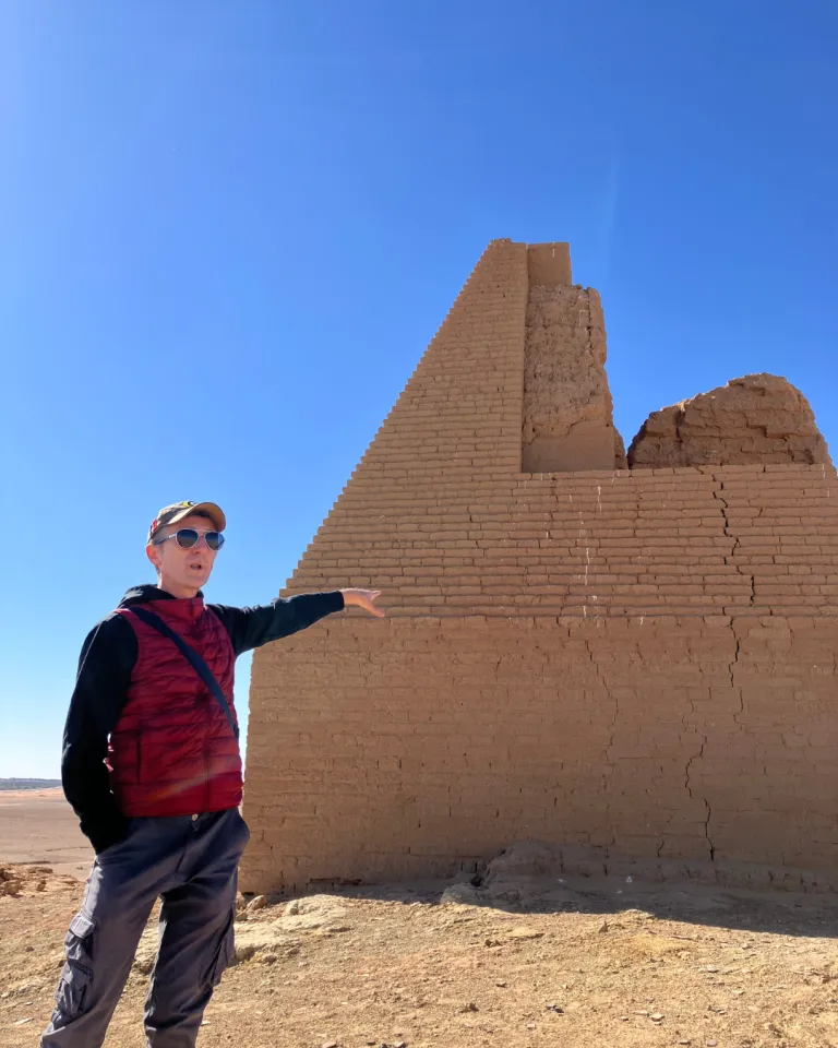 Aravecchia pointing to a wall in the desert