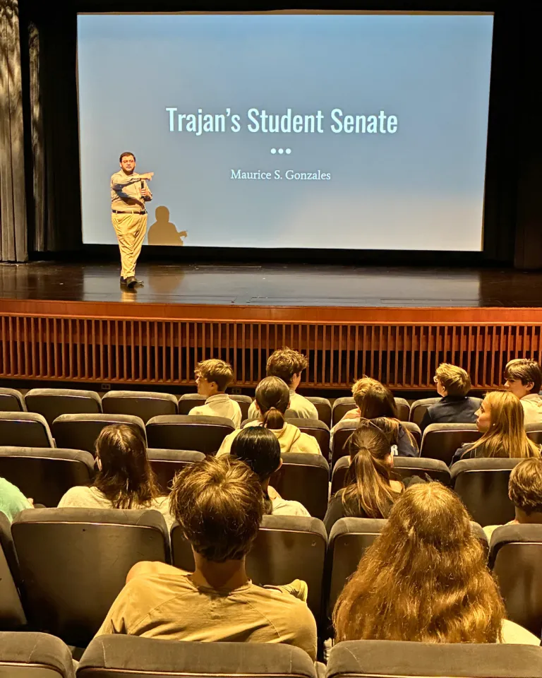 Gonzales in front of a screen Trajan's Student Senate