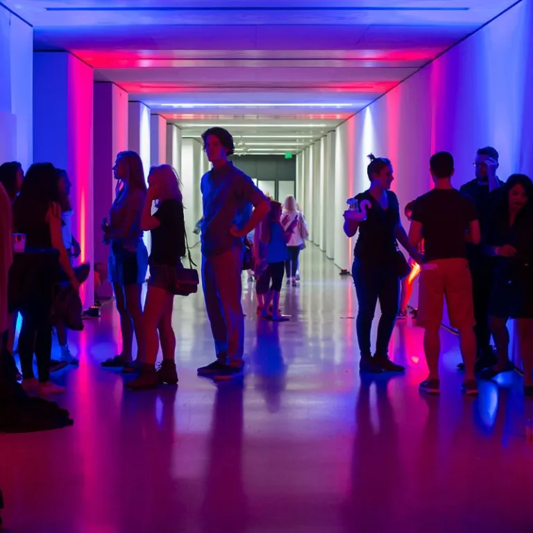 people in a hall of pink and blue neon lights