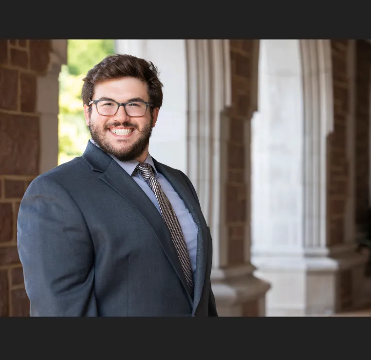 Jake Pawlush standing in front of WashU arches