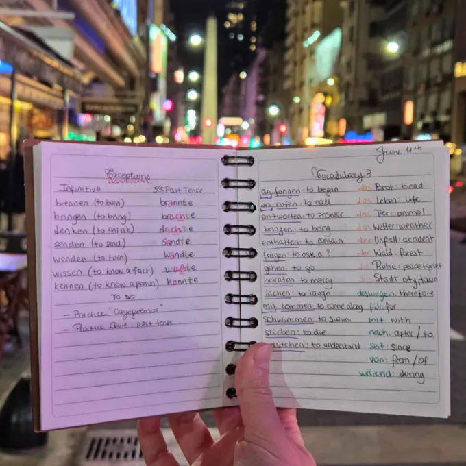 Notebook filled with German notes framed by the Buenos Aires skyline