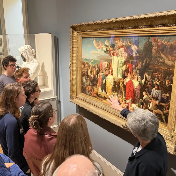 a SLAM docent speaks about a painting to a group of students